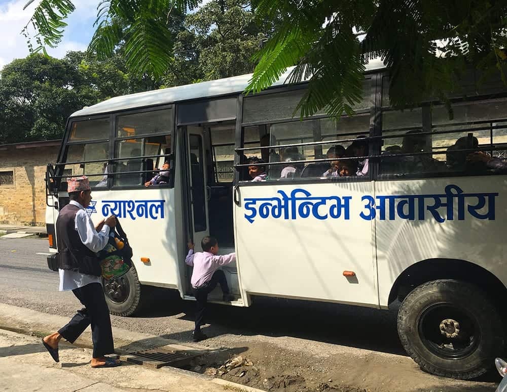 kid runs to catch school bus in Pokhara Nepal