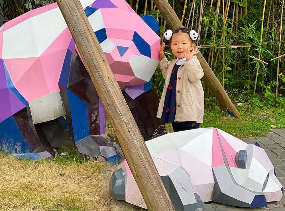 Chinese toddler with panda sculptures at Panda Base