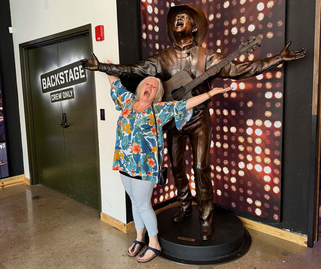 Megan with Garth Brooks statue at the entrance to Friends in Low Places!