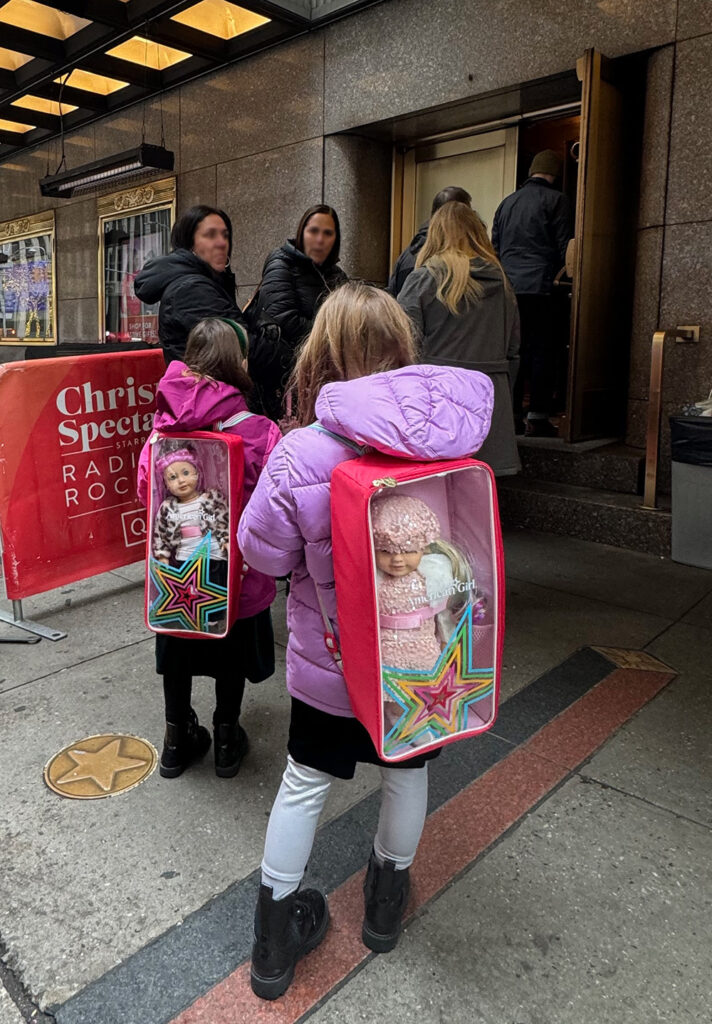 Girls with American Girl dolls lined up to see Rockettes
