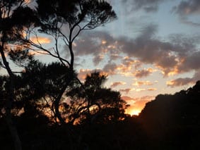 The sun lurking behind the mountains as it slowly rises to the horizon, which is an everyday view from the The Sanctuary at Bay of Islands.