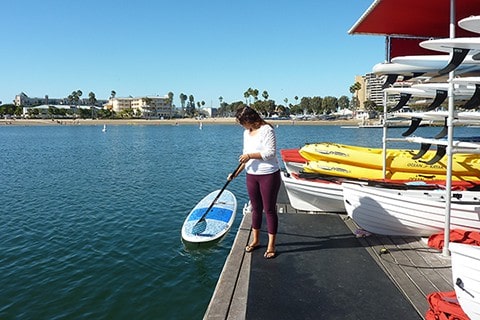 Getting on paddle board from pier