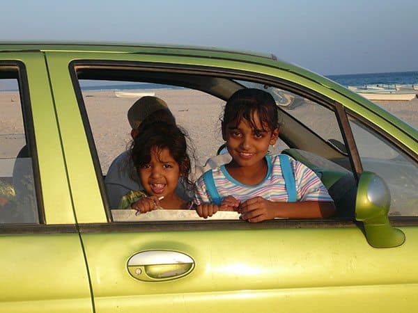 Omani children looking out from the car window smiling for a quick photo op during my 8 days in Oman.