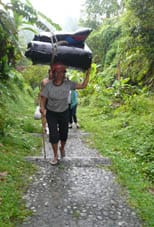 Rafting lady assistant carrying the deflated rafts during our white water rafting in Bali.