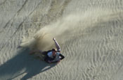 Riding boogie board on sand dunes