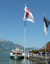 A white paddle steamer docked in Lake Lucerne.