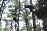 The instructor trying to grab a kid who's stuck hanging on the line, unable to move.