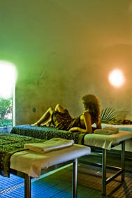 A woman laying down in a bed waiting for her masseur to massage her body.